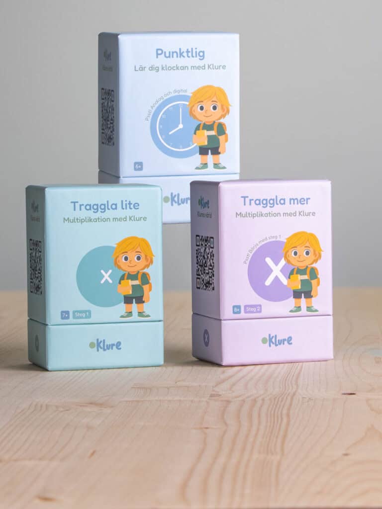 Tre boxar med Klure-spel för att lära sig klockan, multiplikation och addition.